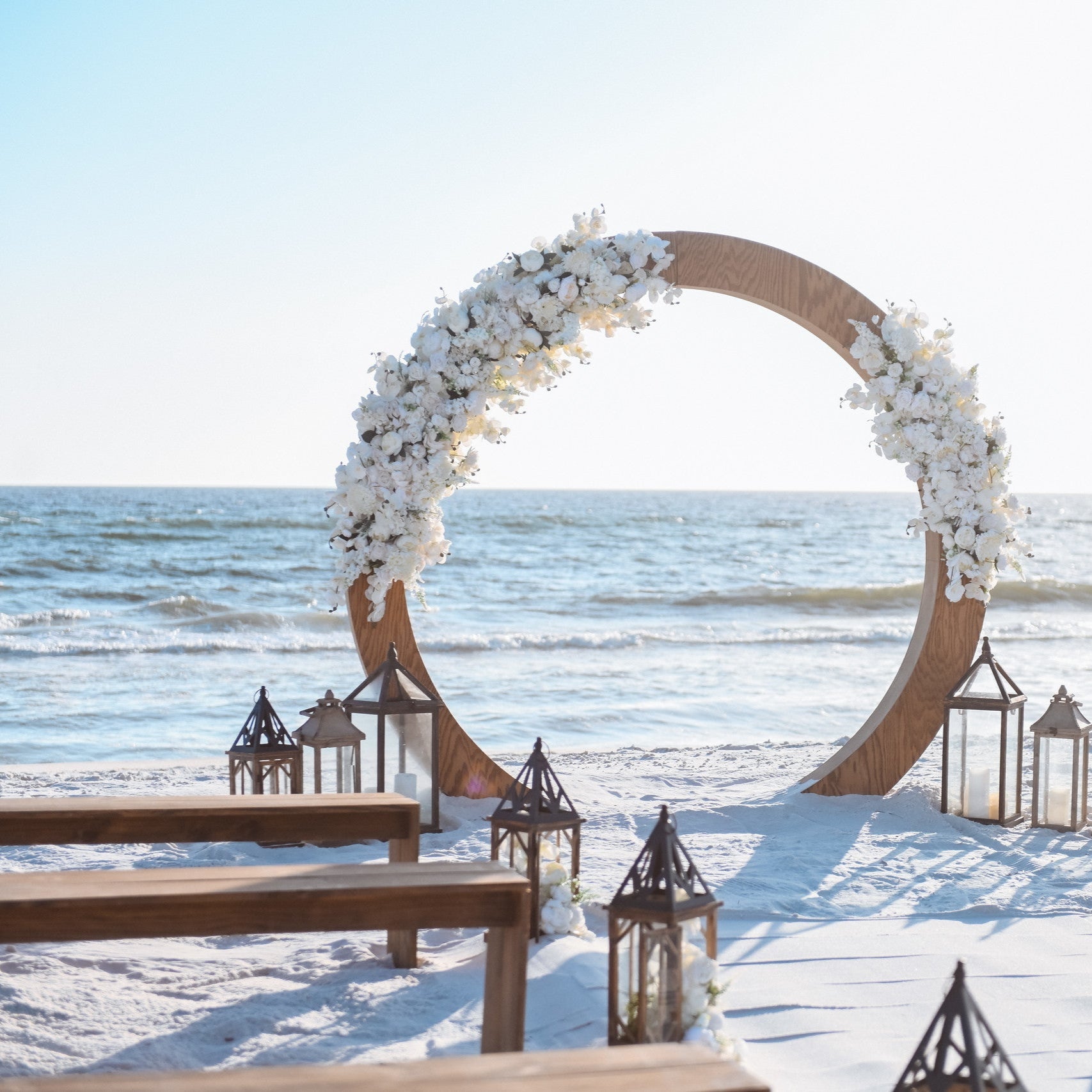 Brown wood bench rental and matching wood moon gate circle arbor arch in Panama City Beach Florida