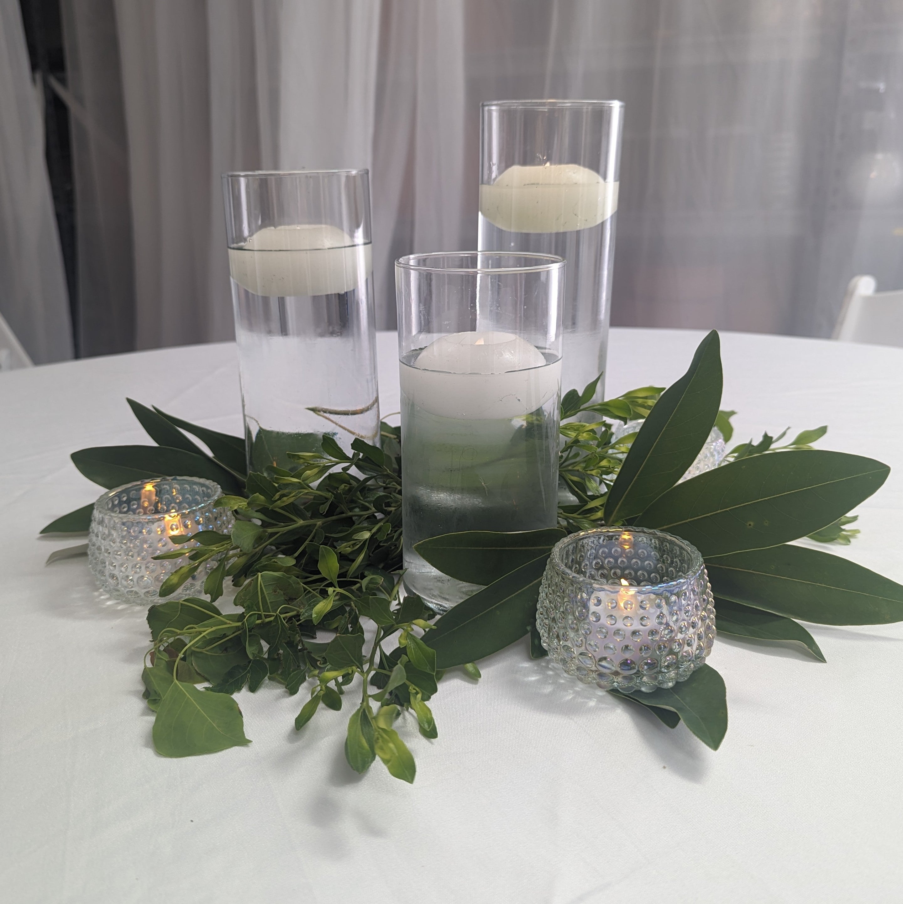 Cylinder vase cluster centerpiece with fresh greenery and led candles
