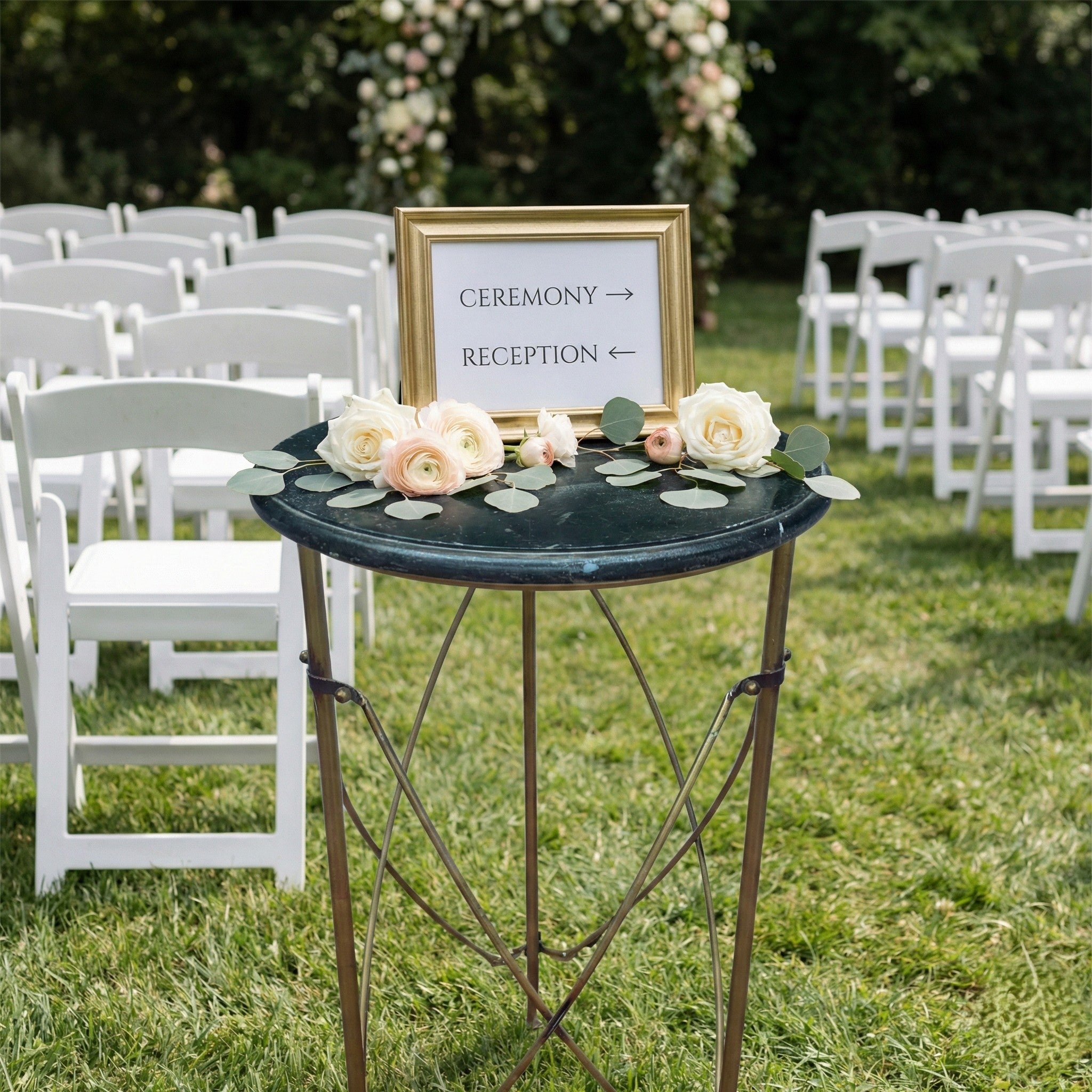 Decorative table rental with flowers and a sign indicating ceremony and reception areas at an outdoor wedding venue.