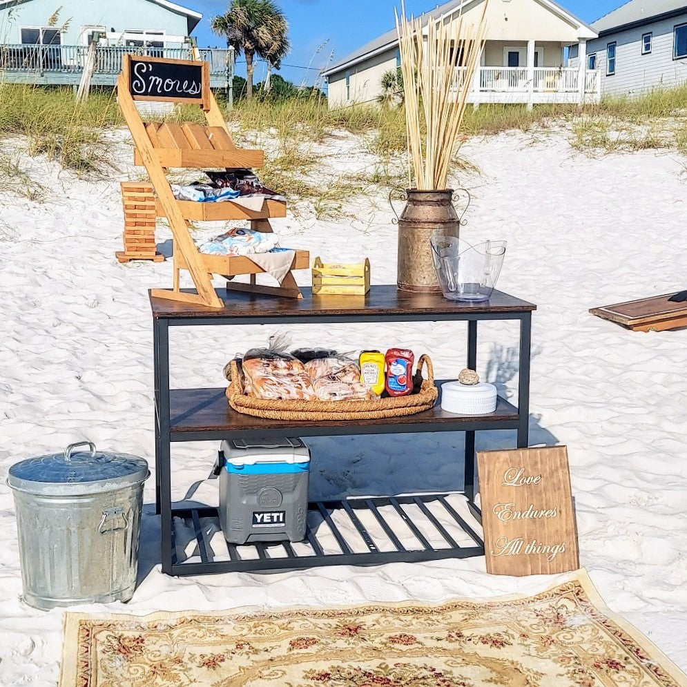 Outdoor setup with a cart, cooler, and decorative items on a sandy beach.