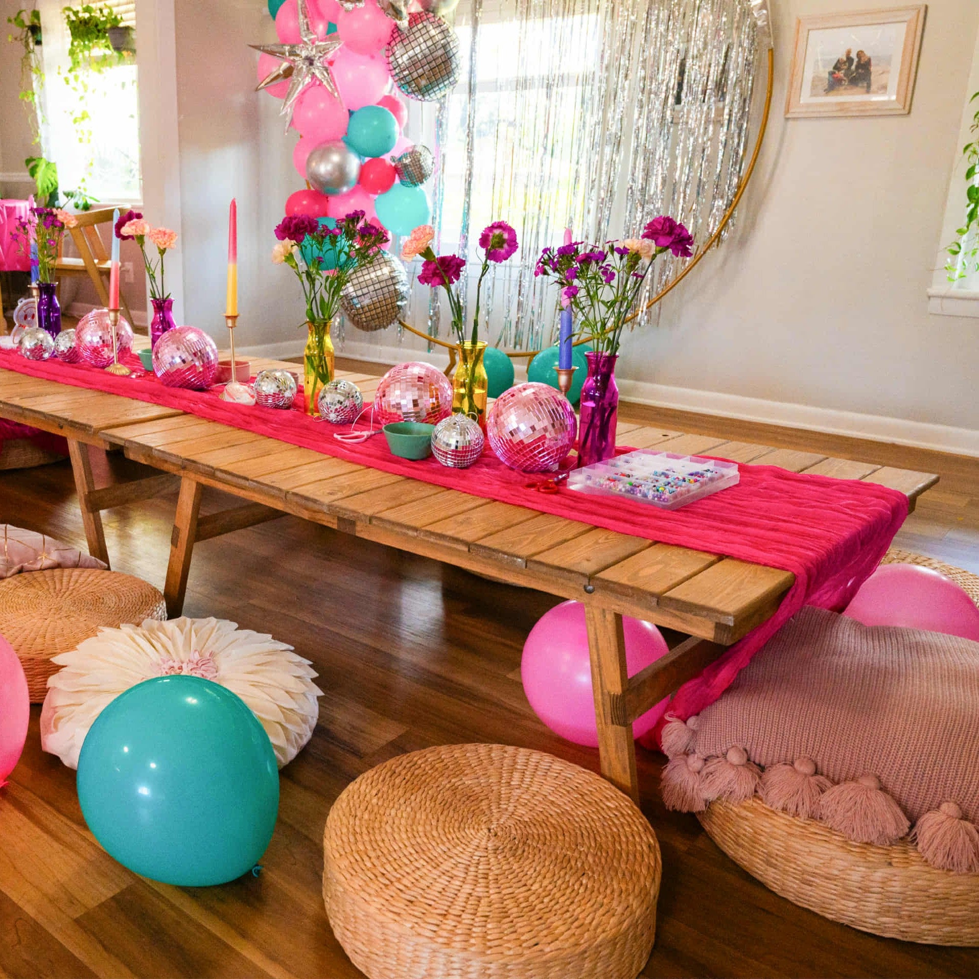 Decorated room for birthday party with low profile picnic table rentals, balloons, and flowers.