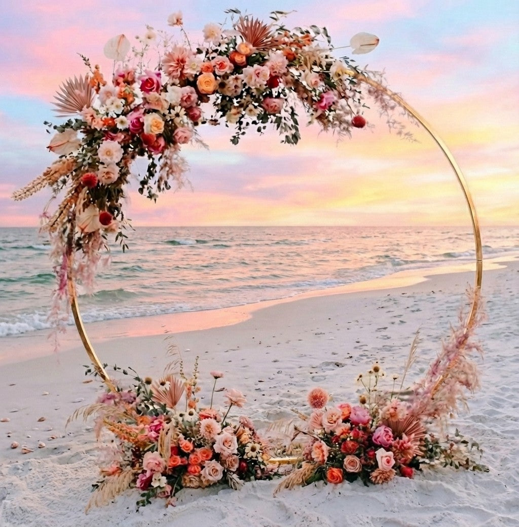 Gold Circle Floral arch on a beach with a sunset in the background