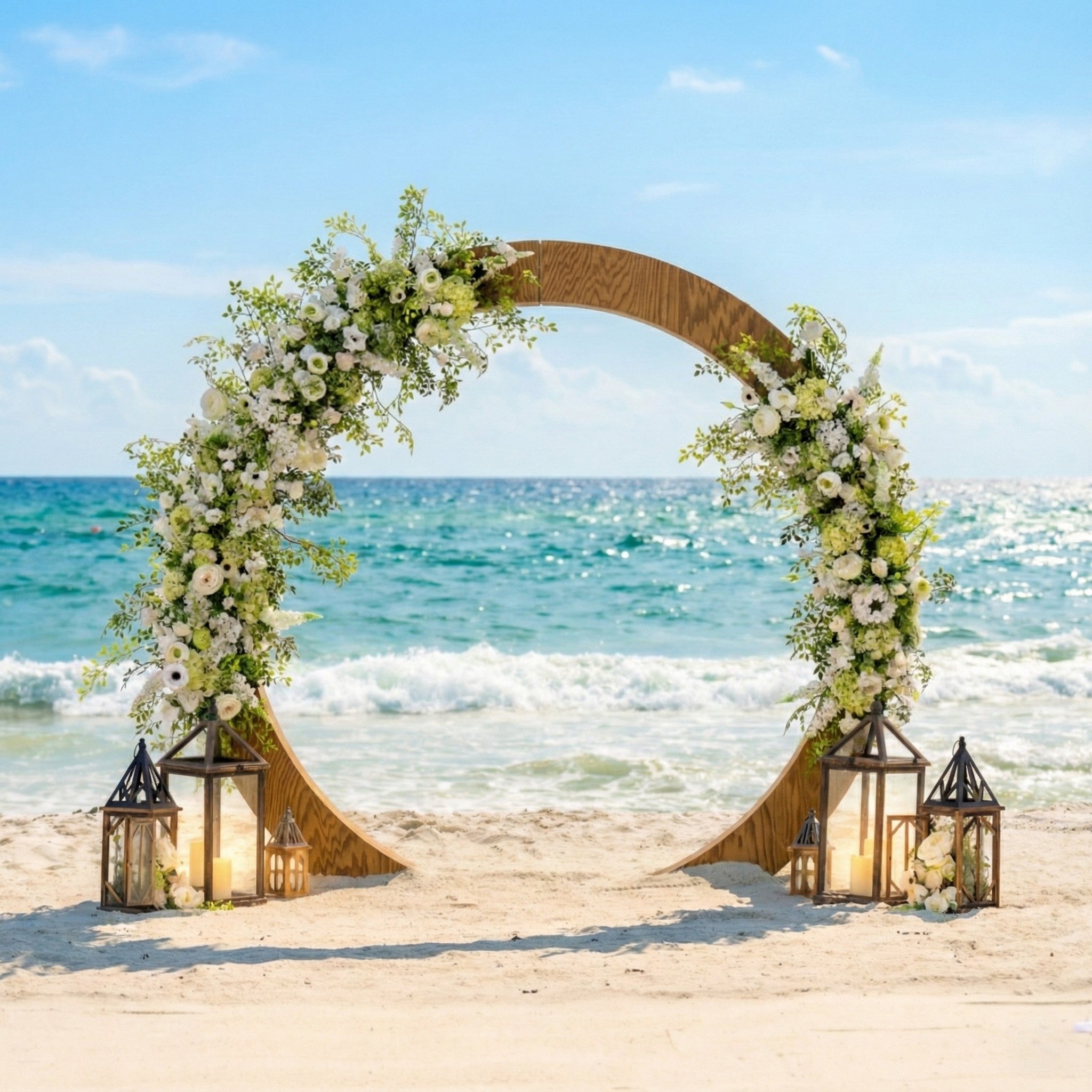Decorative circle wedding arch with flowers and lanterns on a beach with ocean view