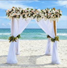 4 post bamboo wedding arbor & chuppah on the beach with classic lush blush and white flowers.