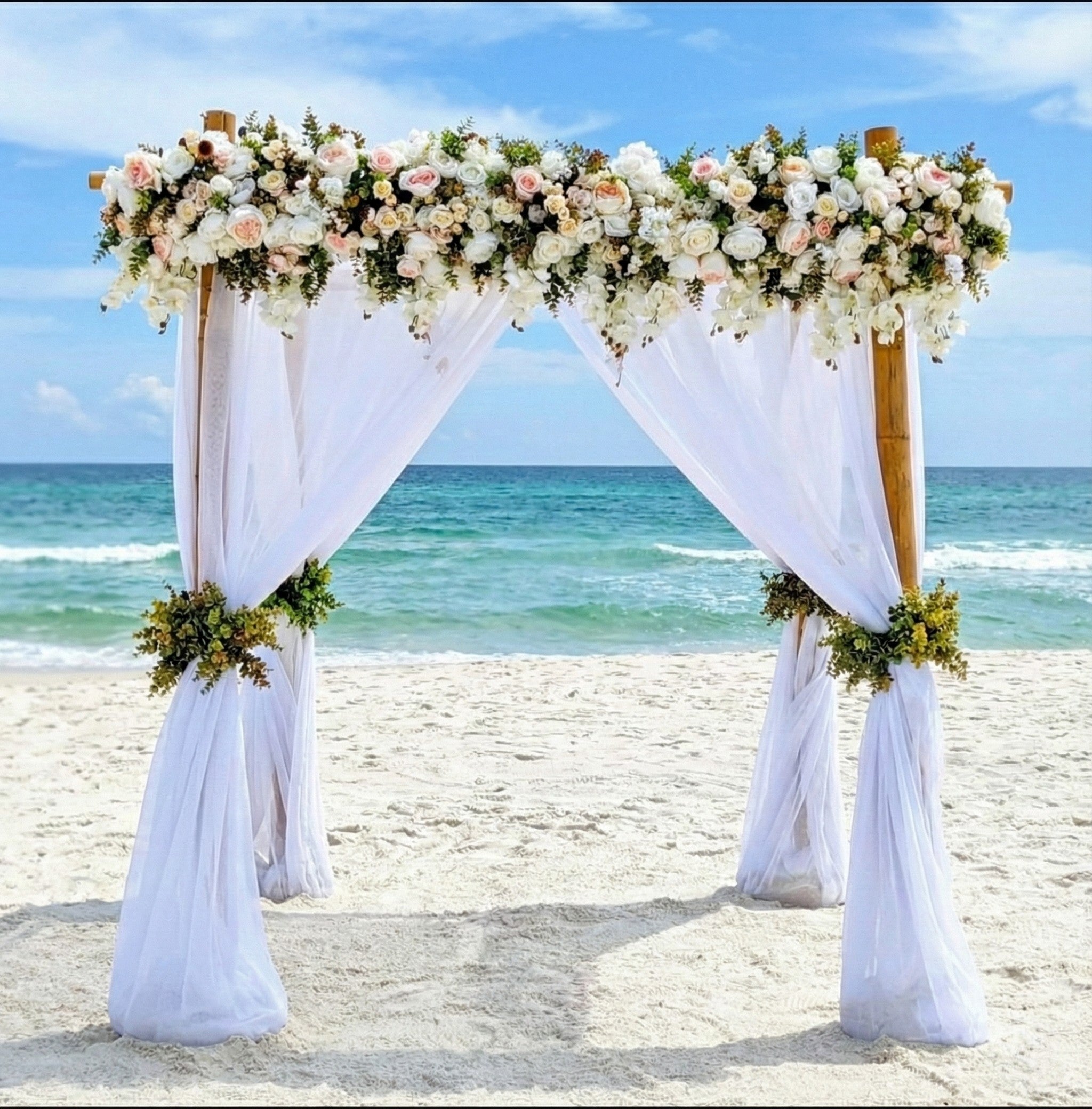4 post bamboo wedding arbor & chuppah on the beach with classic lush blush and white flowers.