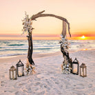 Driftwood wedding arch rental with floral decorations on a beach at sunset in panama city beach 30A