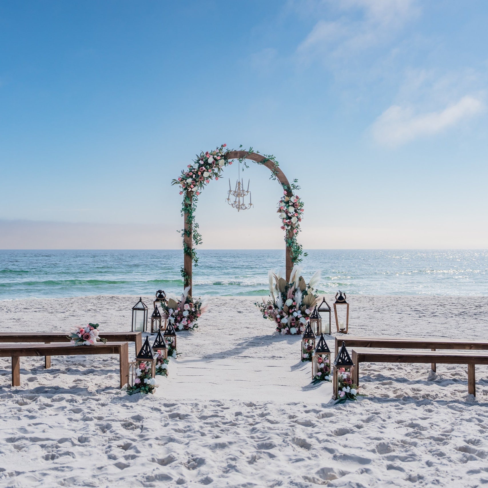 Brown wood wedding bench rentals with matching dome wedding arch arbor with chandelier and custom artificial wedding flower rentals from The Wedding Shop in Panama City Beach Florida PCB