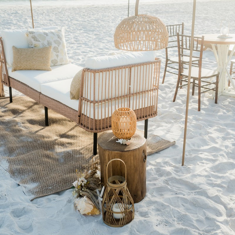 Beachside setting with wicker furniture and lanterns on sand for a beach bonfire on 30a