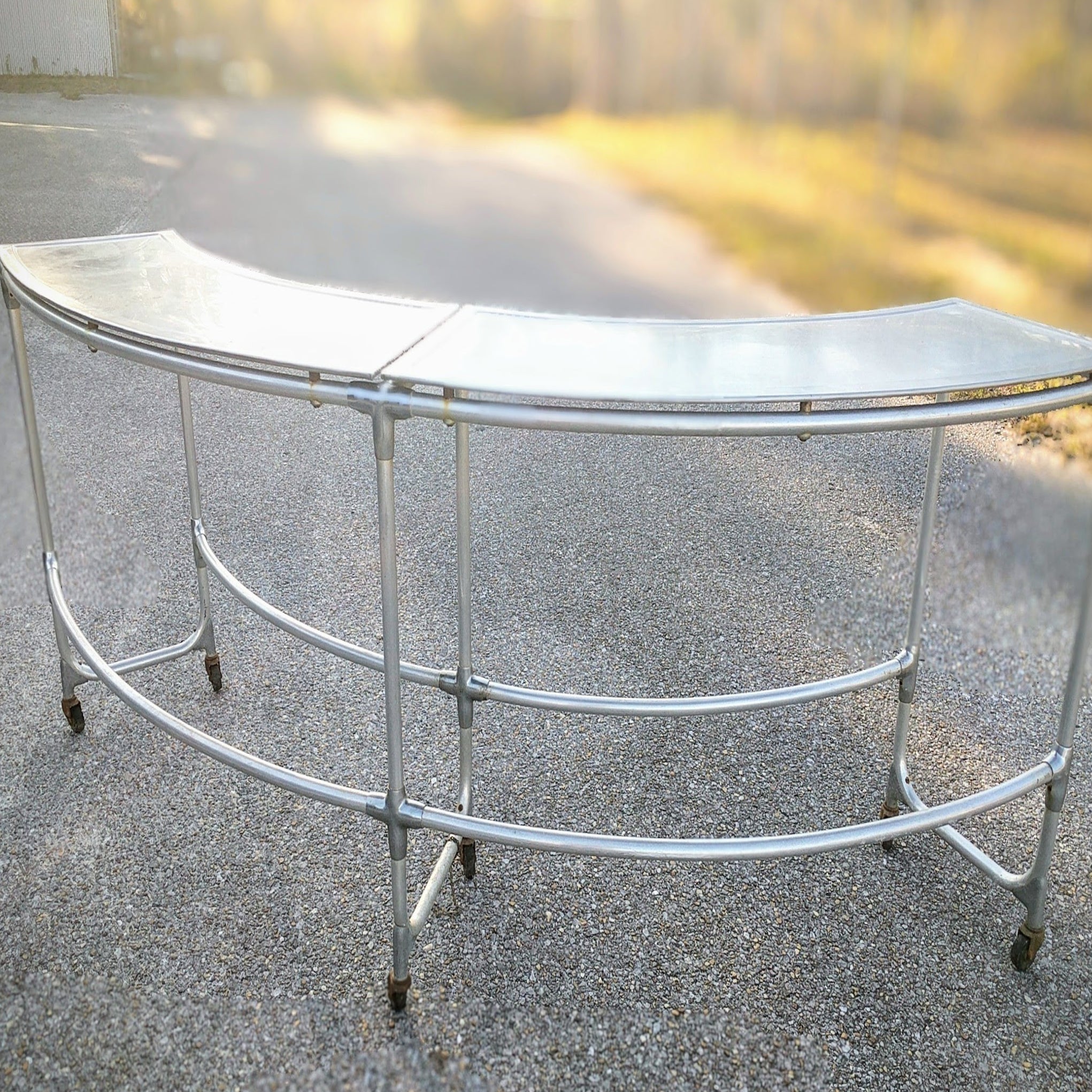 sleek modern curved galvanized metal table for bar or guest seating 