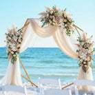 gold polygon wedding arbor with pink and white flowers on the beach in panama city beach