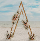 Triangular wooden arch decorated with flowers on a beach