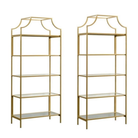 Two gold metal shelves with glass shelves on a white background