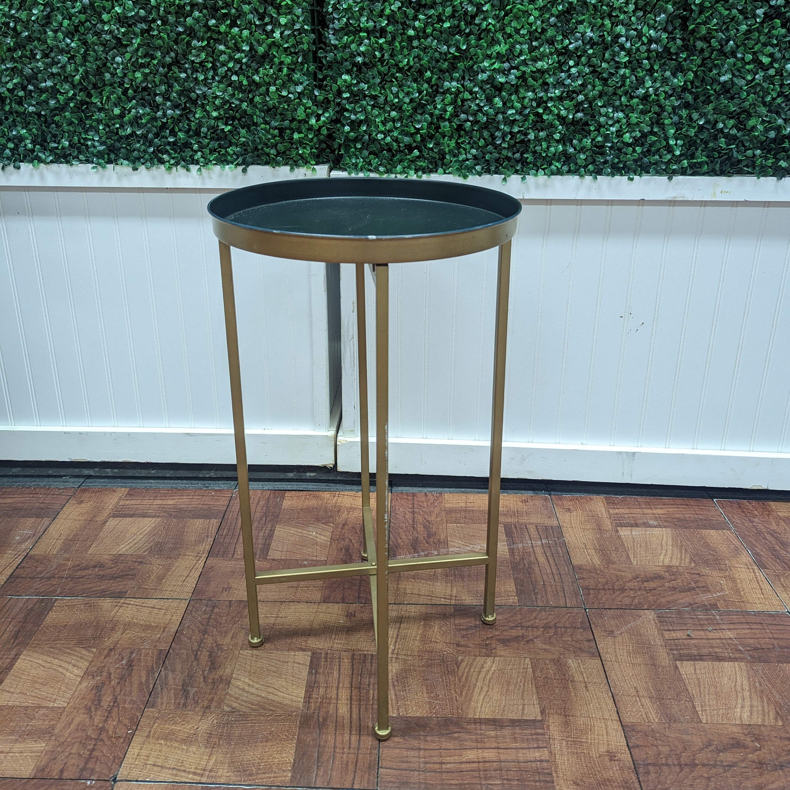 gold unity table with small round black tray top and gold legs 