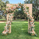 Floral archway decorated with pink and white flowers in a park setting