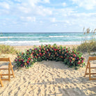 Floral arch on a sandy beach with ocean view