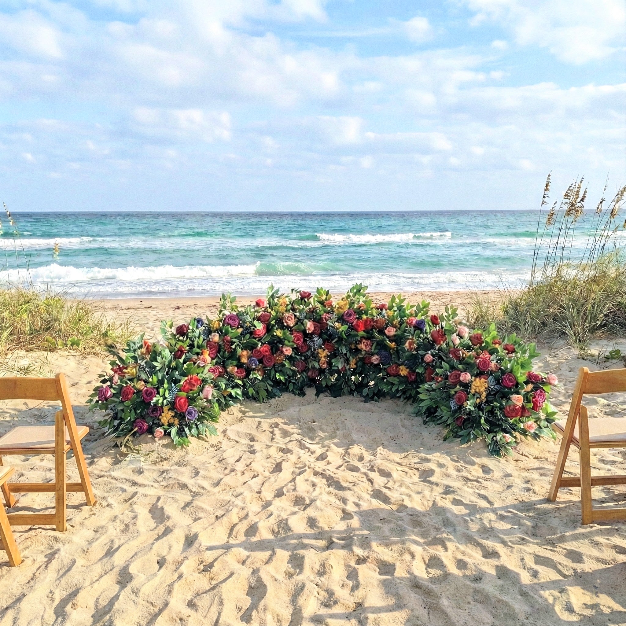 Floral arch on a sandy beach with ocean view