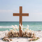 Wooden wedding cross on a sandy beach with ocean in the background