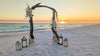 video of driftwood wedding arbor rental on the beach at sunset as waves crash behind it.