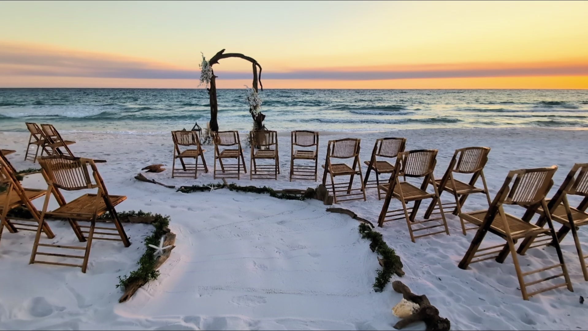 driftwood wedding arbor rental with serpentine aisle design on the beach at sunset