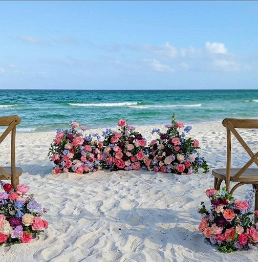 Floral arrangement on a sandy beach with ocean view