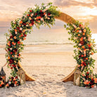 Floral arch on a beach with sunset in the background