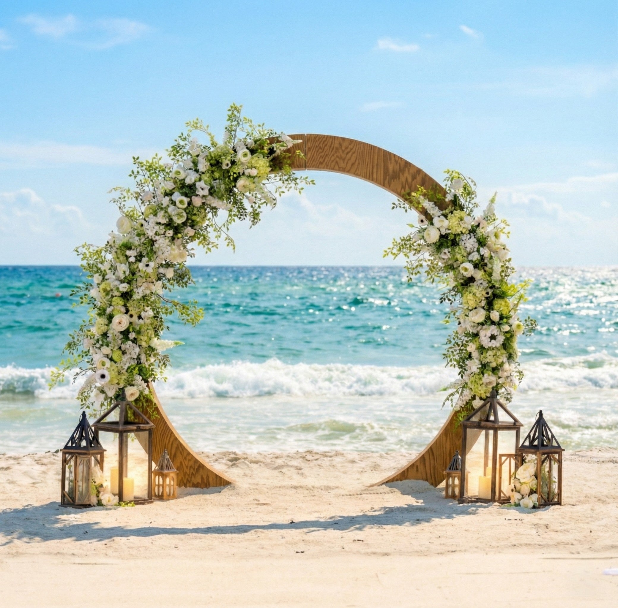 Decorative circle wedding arch with flowers and lanterns on a beach with ocean view